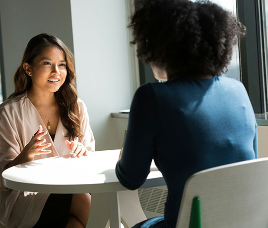 Two ladies having a conversation in an office