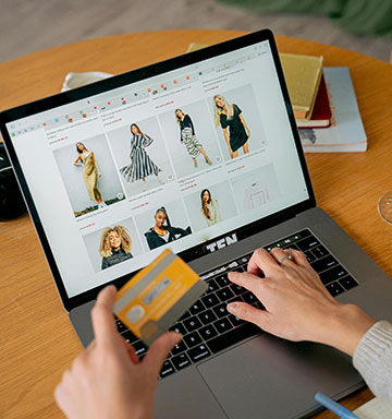 Lady using a laptop computer to make a purchase with her debit card